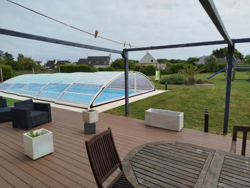 une terrasse avec une piscine et des chaises dans l'établissement Grande maison familiale, à Penmarcʼh