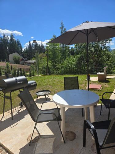a patio with a table and chairs and an umbrella at Vikendica Villa Marija Pale in Pale