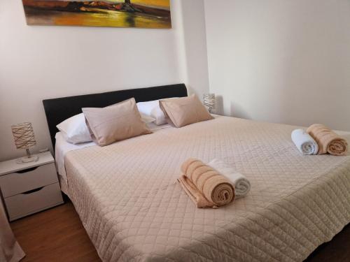 a bedroom with a bed with towels on it at Apartman Prgin in Primošten