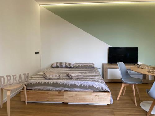a bedroom with a bed and a desk with a television at La casetta al parco in Ponte San Nicolo