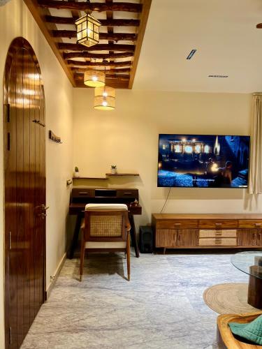 a living room with a piano and a tv at Shiv Sadan in Jaipur
