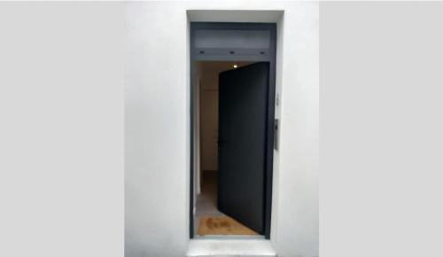 une porte donnant sur un couloir dans un bâtiment blanc dans l'établissement Au Pied de la MER Au Coeur de la STATION Joli Duplex contemporain 2a 4 personnes, à Bénodet