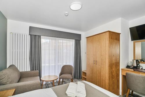 a living room with a couch and a tv at Best Western Greater London in Ilford
