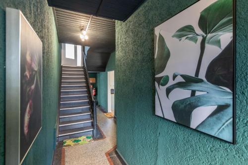 a hallway with green walls and stairs with a painting at Cleveres und gemütliches City-Apartment in Mayen in Mayen