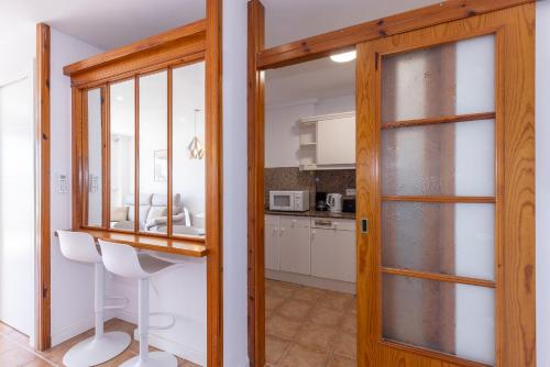 a kitchen with white cabinets and a wooden door at Prime Location Penthouse with Stunning Sea Views in Salou