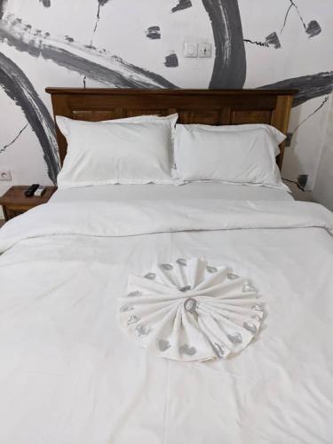 ヤウンデにあるHOTEL MAA MEVFOU Hmmの白いベッド(花の装飾付)