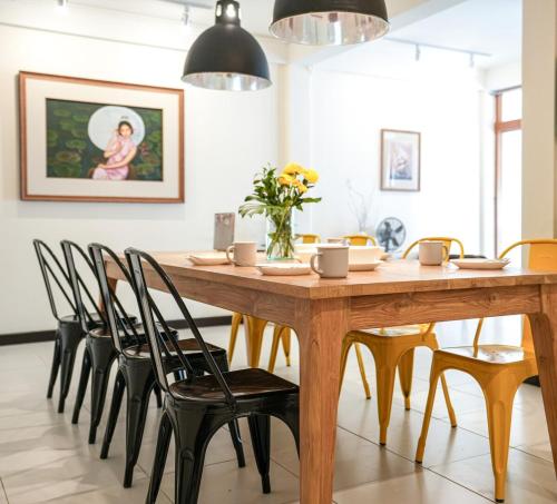 a dining room with a wooden table and chairs at Ombra House No20 in Chiang Mai