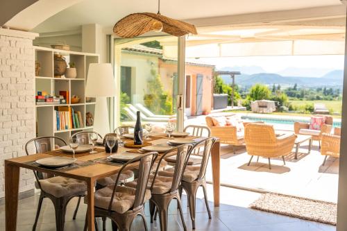 a dining room with a table and chairs and a pool at Villa Bellavista in Marsanne
