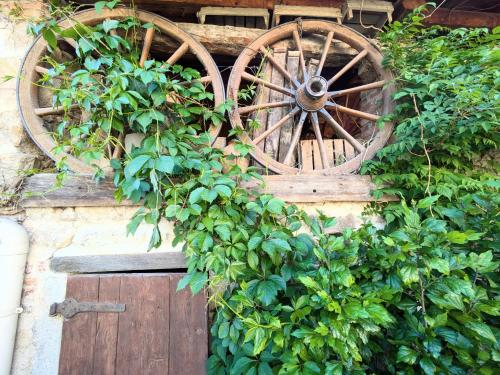 an old wooden wagon wheel sitting on top of a building at La Provende in Bard