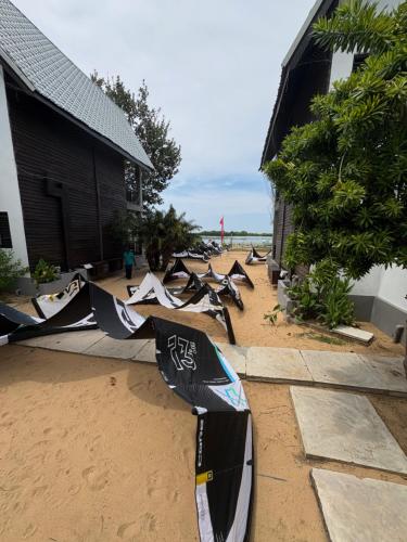 a group of kites laying on the sand on a beach at Downwinder Lagoon Lodge in Kalpitiya