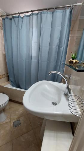 a bathroom with a sink and a shower curtain at Souda Bay View Retreat in Souda