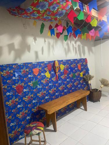 a bench in a room with a wall covered in confetti at Casa no Centro de Campina Grande in Campina Grande