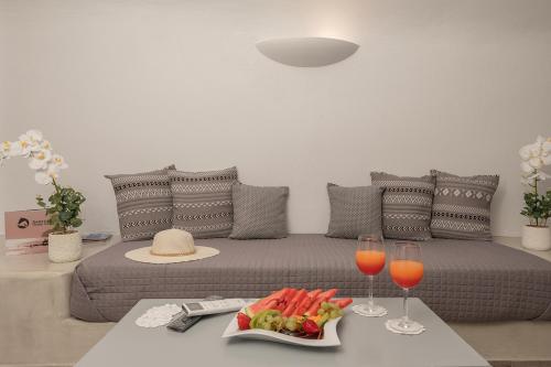 a living room with a bed with a tray of food and wine glasses at The Wine Nest in Megalokhori
