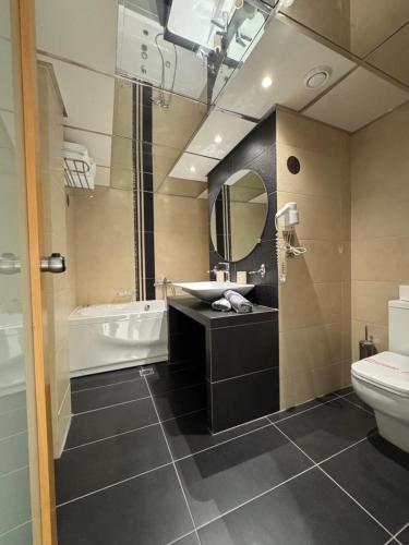 a bathroom with a sink and a tub and a toilet at Messinian Bay in Kalamata