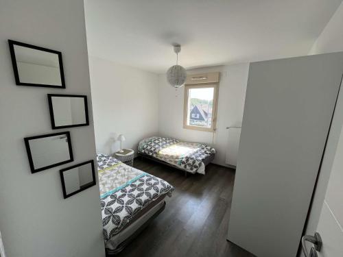 une chambre avec deux lits et une fenêtre dans l'établissement Appartement lumineux 2 chambres à Wimereux, proche plage, avec garage et Wi-Fi - FR-1-675-13, à Wimereux