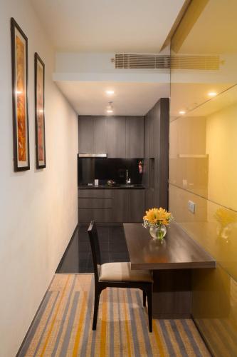 a dining room with a table and a kitchen at Novotel Kolkata Hotel and Residences in Kolkata
