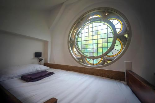 a bedroom with a large round window in the corner at St Michaels Lodge in Richmond