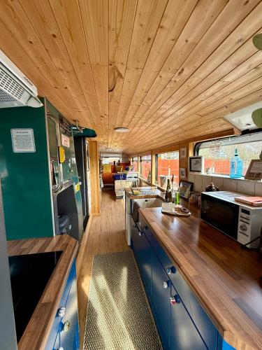 a kitchen with blue cabinets and a wooden ceiling at Ballinadee Bus in Ballinadee