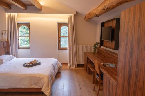 a hotel room with a bed and a television at Hotel Rosa delle Alpi in Esino Lario