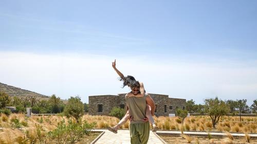 Agios FokasにあるEmerald Tinosの建物の前に立っている男性