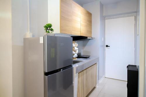 a kitchen with a stainless steel refrigerator and wooden cabinets at Urban Oasis with Skyline View in Manila
