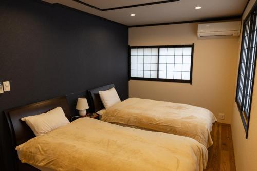 ein Schlafzimmer mit zwei Betten und einem Fenster in der Unterkunft Family-Friendly, 2-Story Kyoto House, Walk to Gion in Kyoto