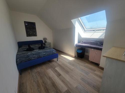 a bedroom with a blue bed and a window at Chambre d'hôtes Goustranville in Goustranville