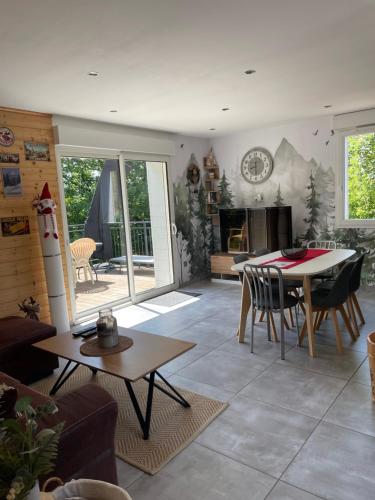 un salon avec une table et une salle à manger dans l'établissement Gîte des Brimbelles, à La Neuveville-devant-Lépanges