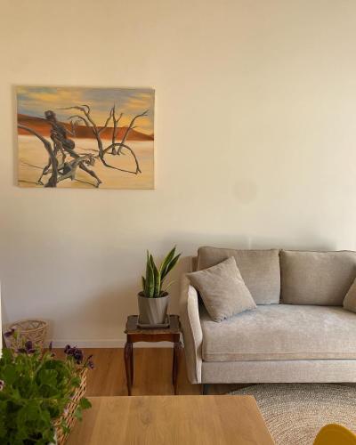 a living room with a couch and a painting on the wall at Matar baYaar מטר ביער in El-Rom