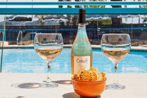 two glasses of white wine and a bowl of peanuts at Hôtel La Nartelle in Sainte-Maxime