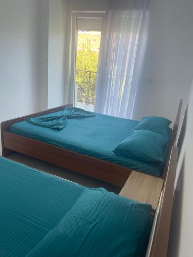 two beds in a room with a window at S3 Apartment 0 in Margjonaj