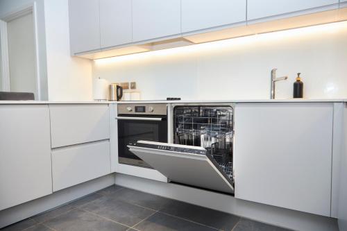 a white kitchen with a dishwasher in the middle at Cosy Two bedroom Apartment in Manchester in Manchester