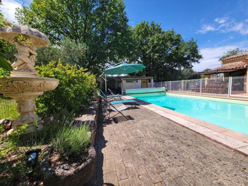 - une piscine avec un parasol à côté de la piscine dans l'établissement Studio calme proche Aix & mer, à Gardanne