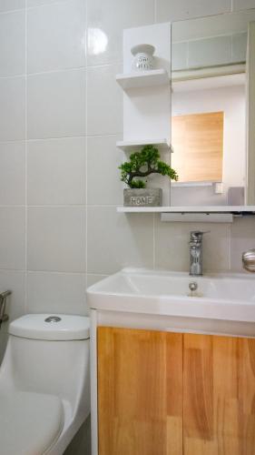 a bathroom with a sink and a toilet at Urban Oasis with Skyline View in Manila