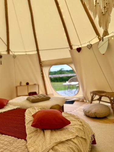 a room with two beds in a tent at Tipi nuit insolite en pleine Nature in Glanville