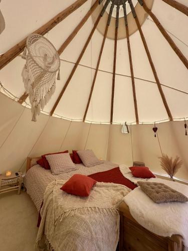 a bedroom with two beds in a tent at Tipi nuit insolite en pleine Nature in Glanville