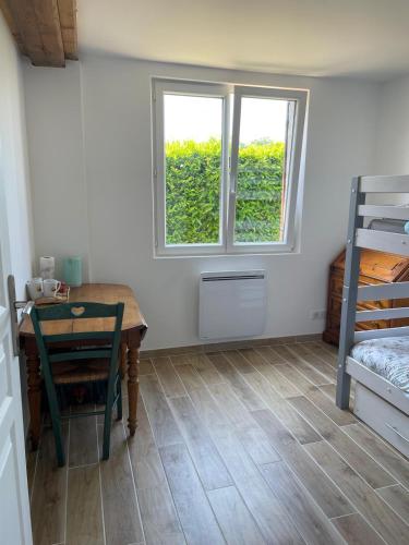 Cette chambre comprend une table, un lit et une fenêtre. dans l'établissement Logement : 2 chambres (5 couchages), salle de bain, à Pierrefitte-sur-Sauldre