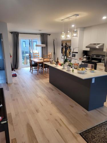 a kitchen and living room with a table and a counter at Longueuil homestay in Longueuil