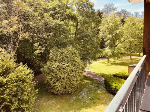 a view from the balcony of a yard with trees at Opale Sun Hardelot in Neufchâtel-Hardelot