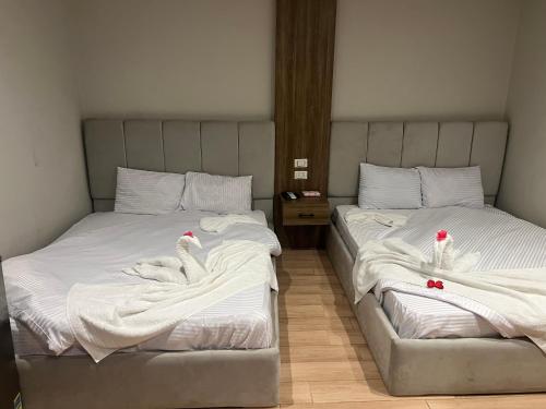 two beds with white sheets and red bows on them at Isis pyramids in Giza