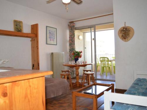 - un salon avec une cuisine et une table avec des chaises dans l'établissement Studio 4 personnes proche plage, animaux admis, Saint-Cyprien - FR-1-225D-2, à Saint Cyprien Plage