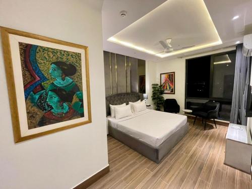 a bedroom with a bed and a painting on the wall at Aurum Heights Gateway Prestige Luxury Apartments - Gulberg Lahore in Lahore