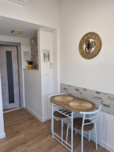 a kitchen with a table and two chairs and a clock at Studio Apartment Đuli Rabac with private hot tub and free parking in Rabac