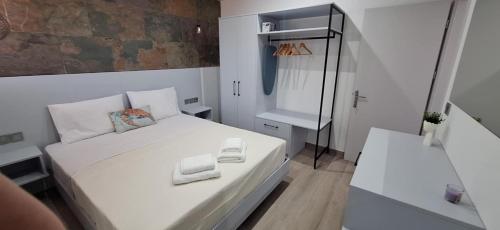 a small bedroom with a white bed and a mirror at Otium Studios in Limenaria