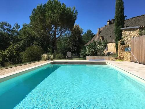 une piscine devant une maison dans l'établissement La Prandie, à Valojoulx