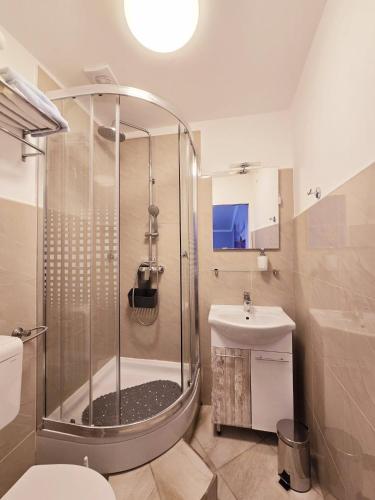 a bathroom with a shower and a toilet and a sink at Guesthouse Korzo in Rijeka