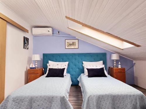 a bedroom with two beds and a blue wall at Guesthouse Korzo in Rijeka