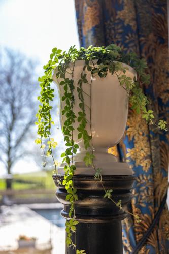 a vase with a plant in it on a pole at Le Domaine de la Haye Chambres d'Hôtes in Saint-Christophe-du-Bois