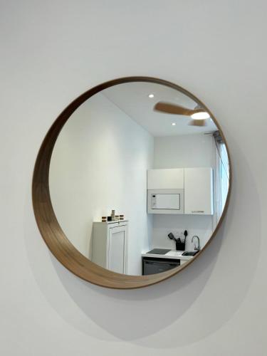 - une cuisine avec un miroir sur un mur blanc dans l'établissement Cosy studio le port, à Nice