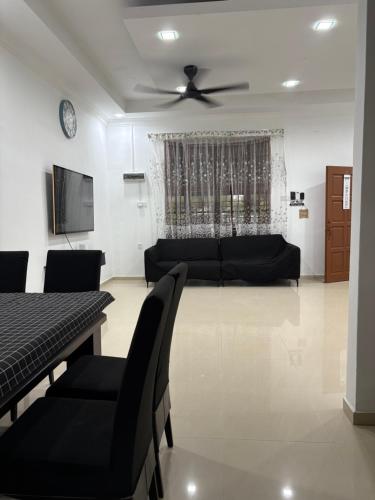 a living room with a couch and a ceiling fan at Bidor Homestay in Bidur